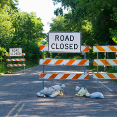 Road Closed barricade on a road with trees along the road