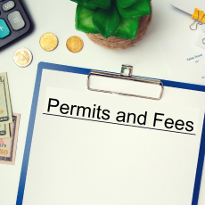 Blue clipboard with paper titles permits and fees